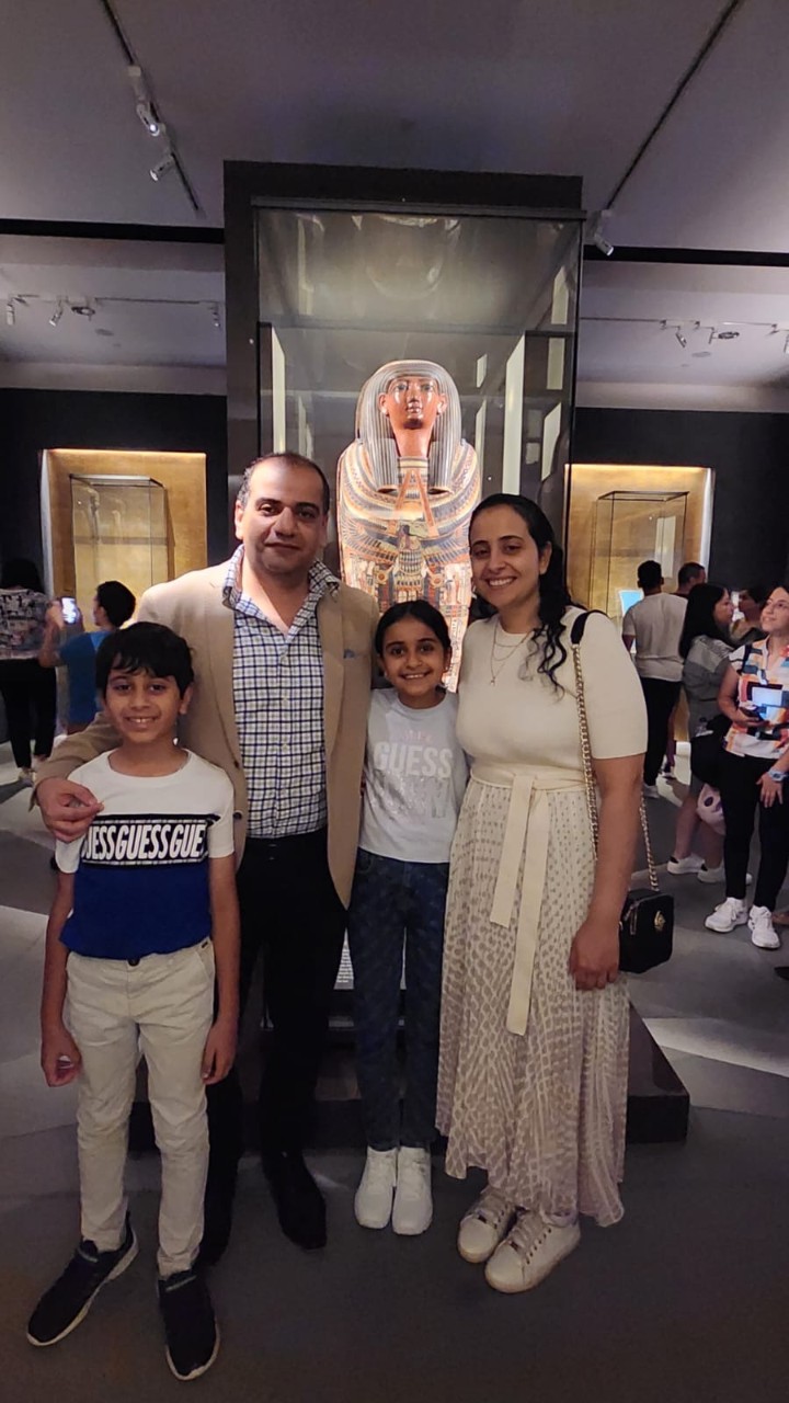 A family standing in front of a mummy's coffin at the Chau Chak Wing Museum