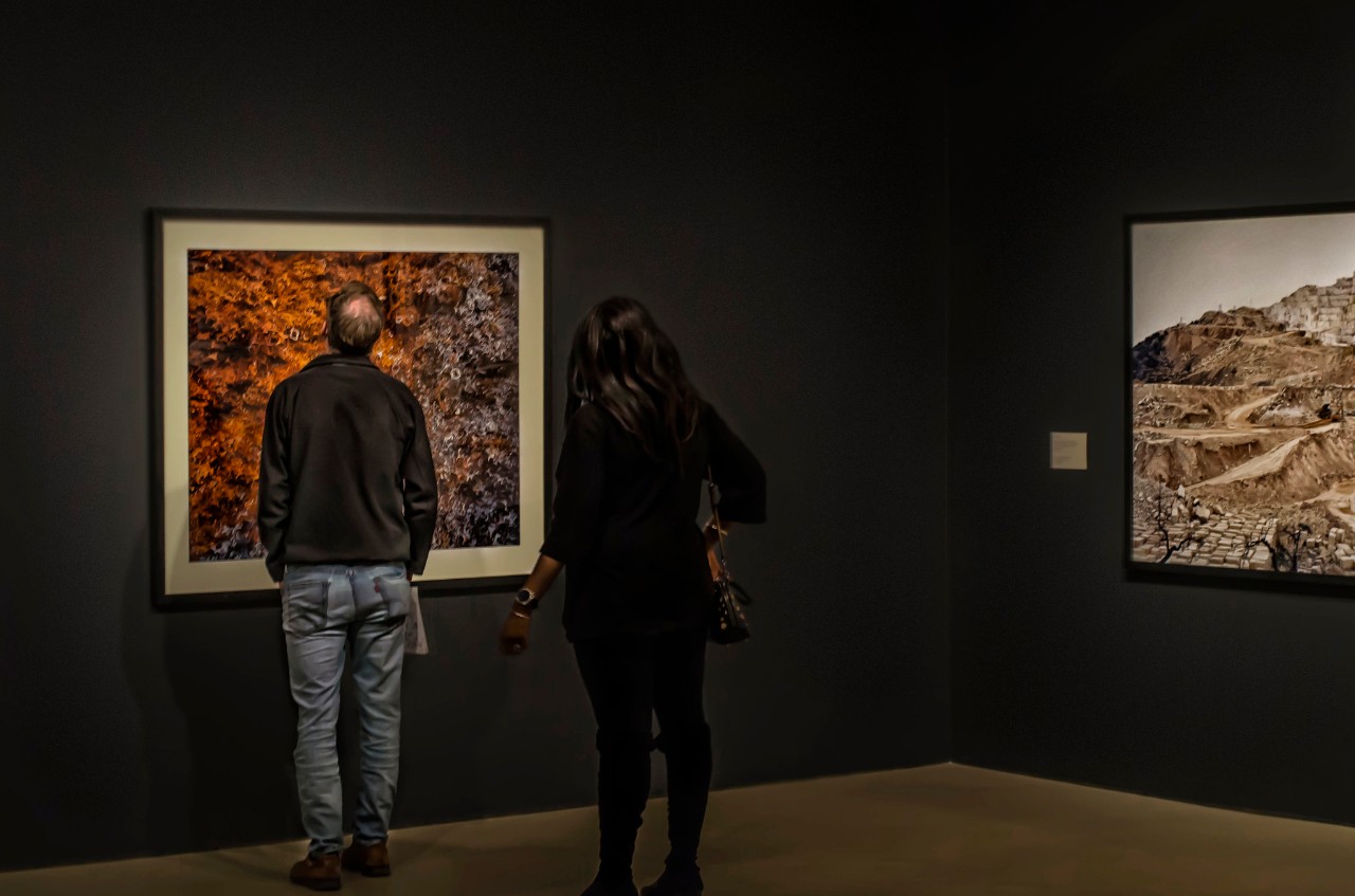 Photo of two people looking at modern paintings in an art gallery.