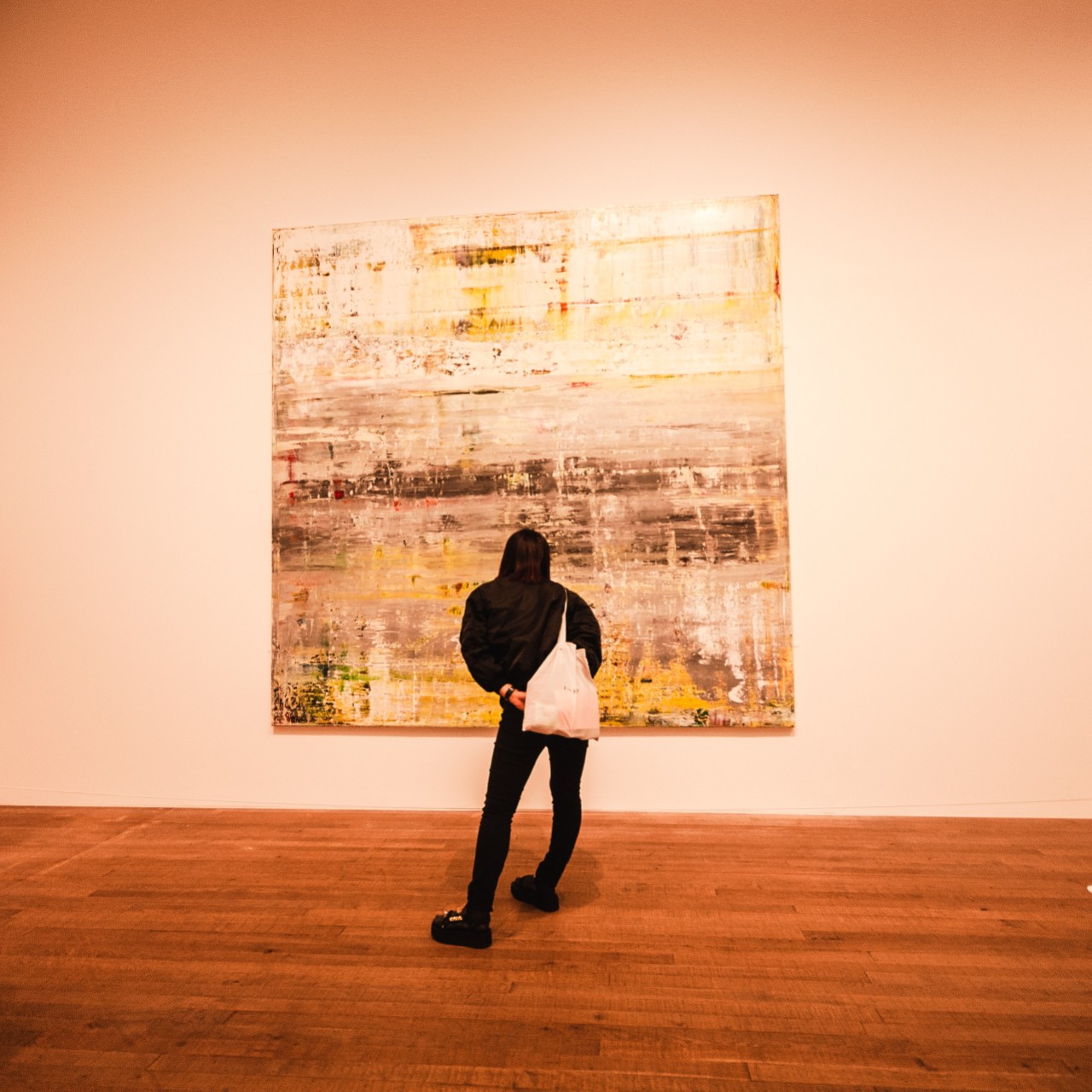 Photo of a woman studying a large painting