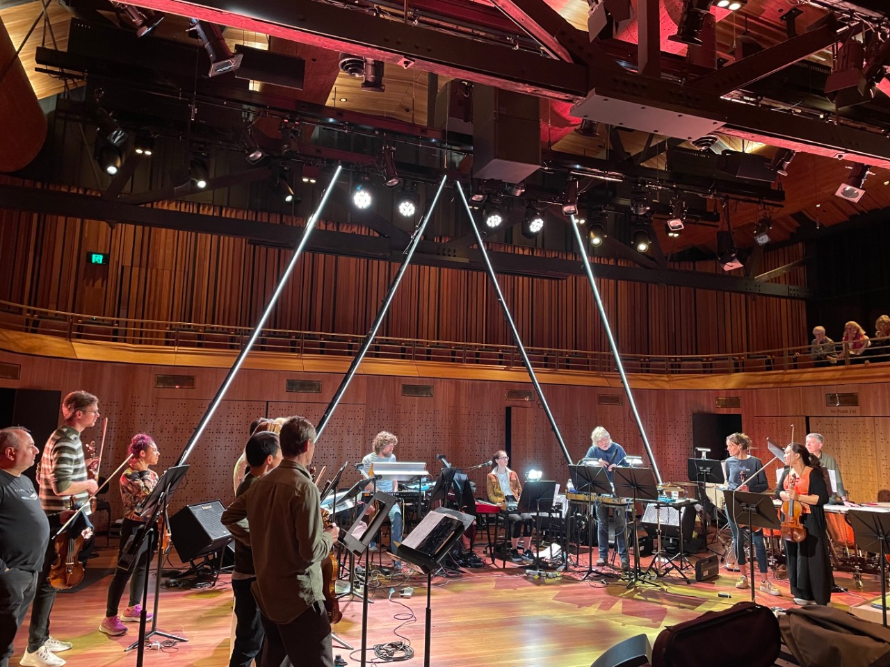 a rehearsal room with classical musicians in it