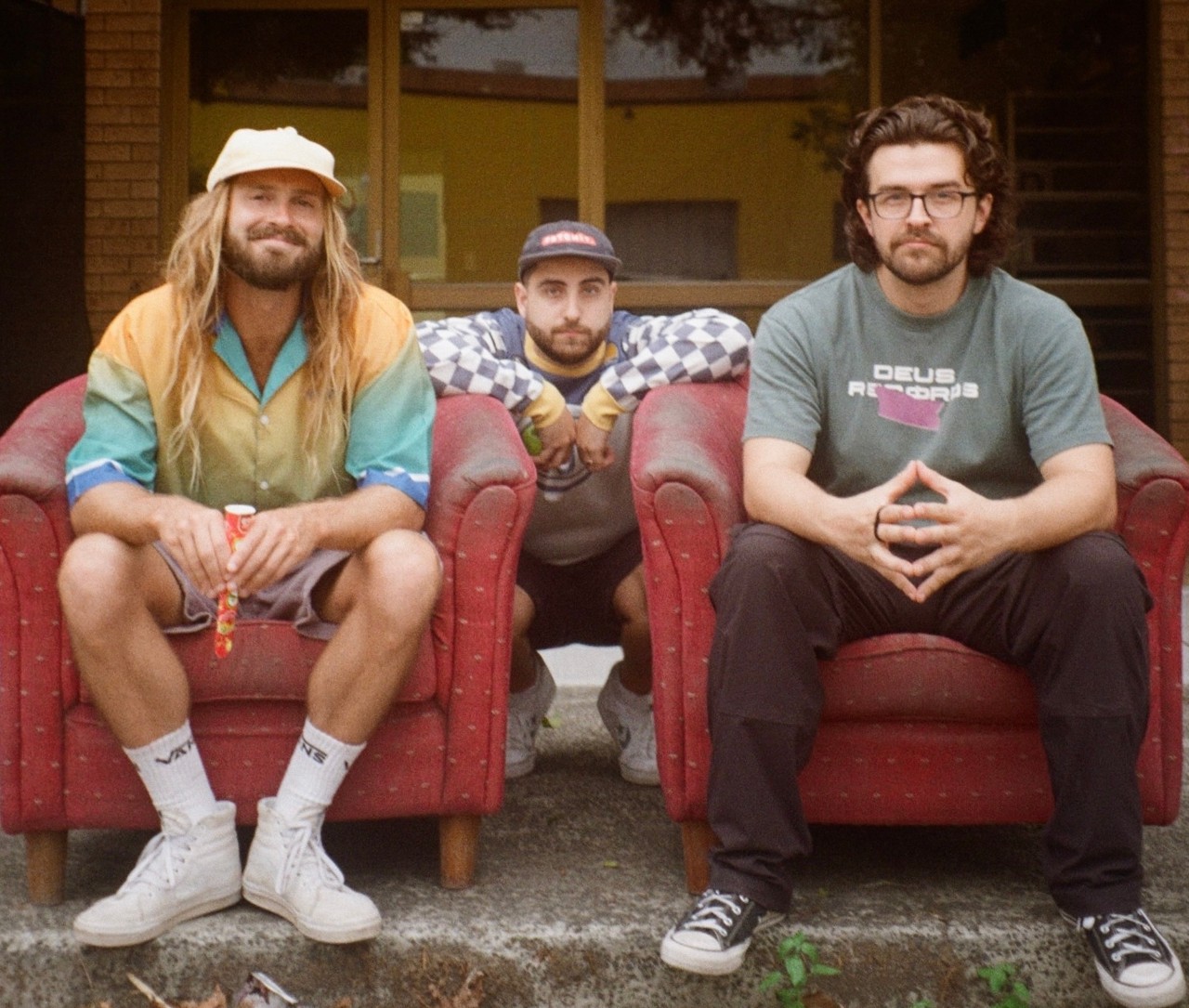 three men sitting on a step smiling
