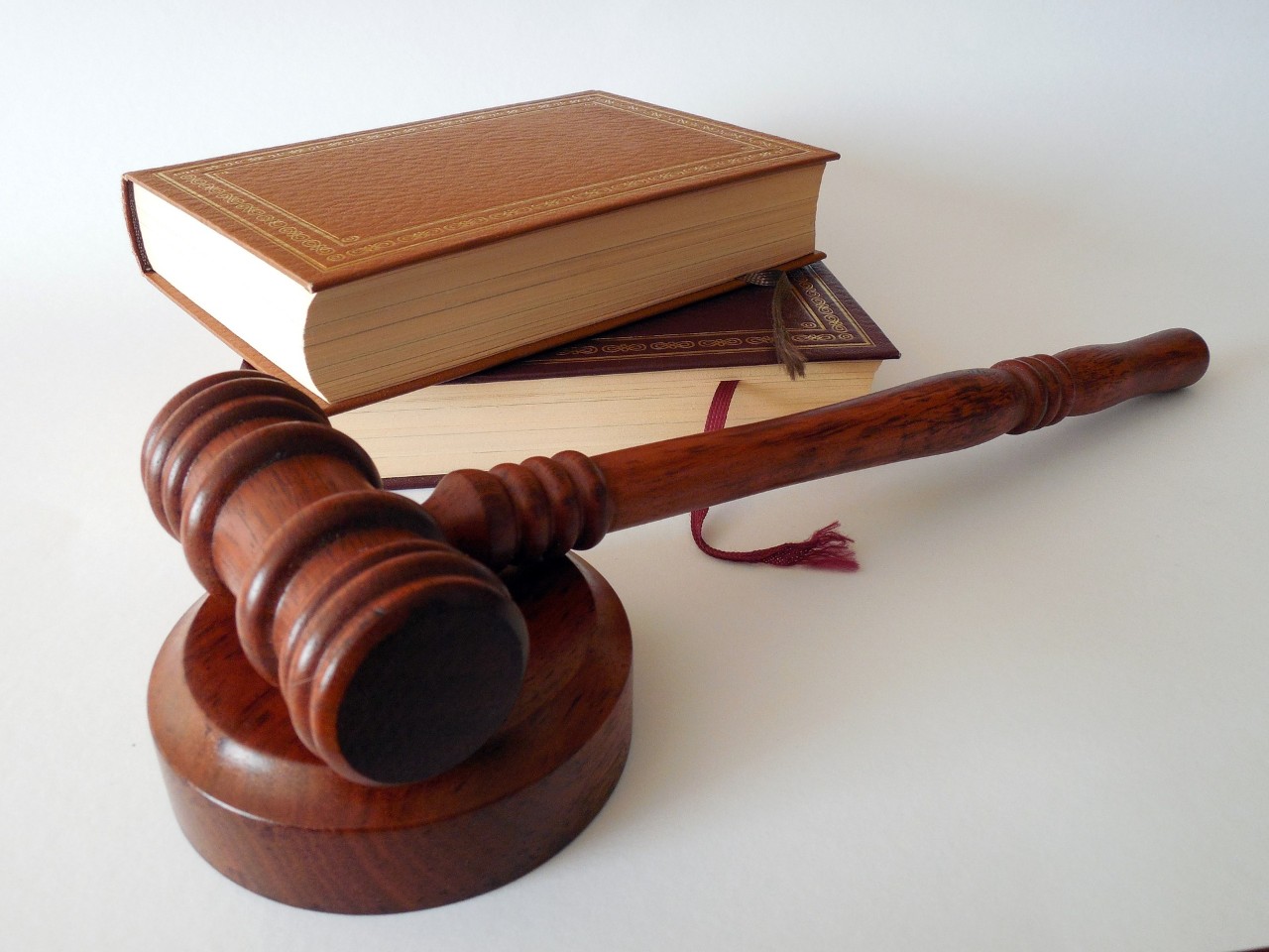 A gavel in the foreground, law books in the background. 