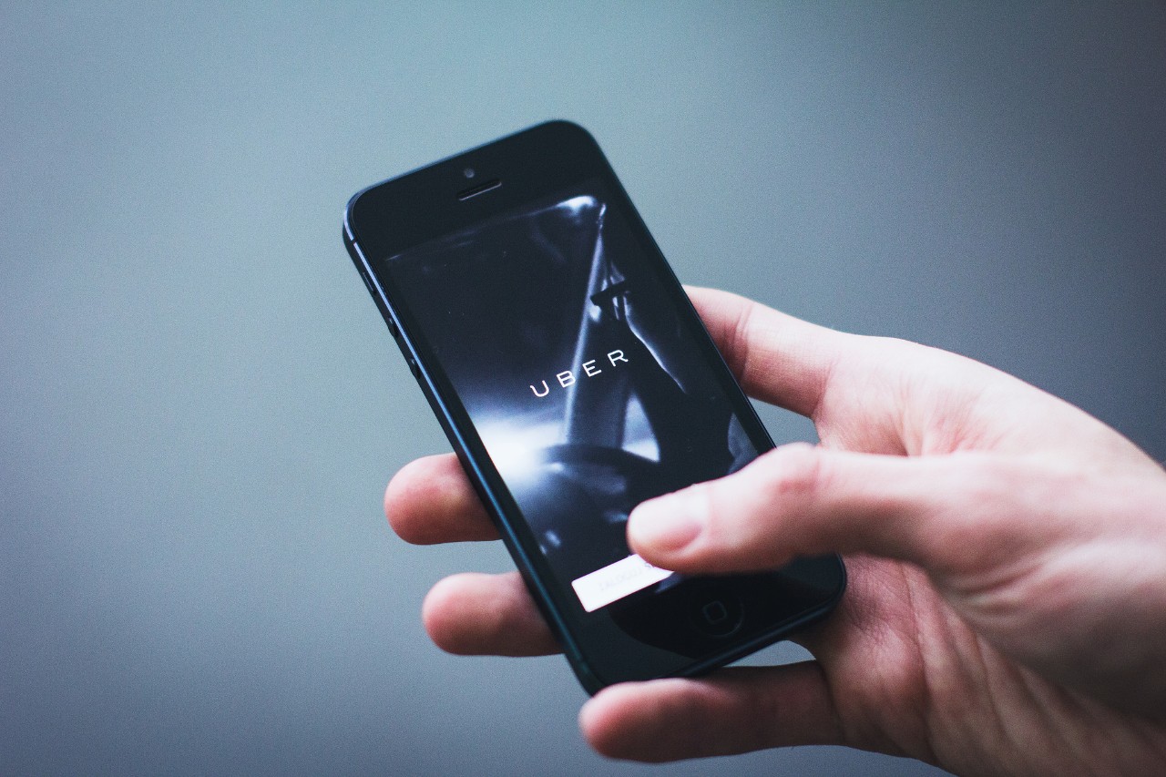 Person using the Uber app on their smartphone. 
