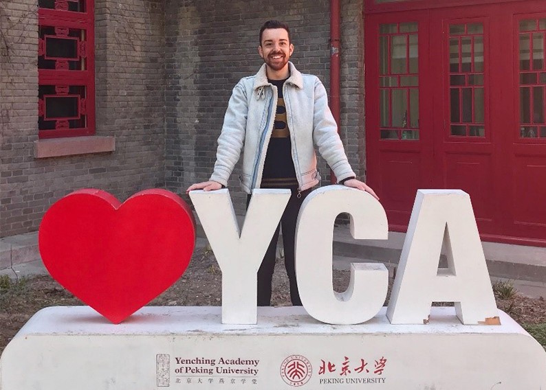 Heath Sloane leans on 3D letter featuring a heart and YCA 