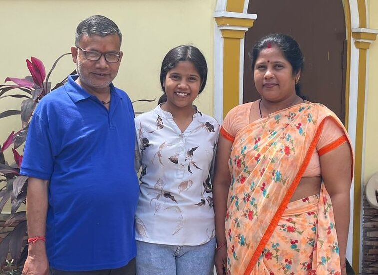 Female student standig with her parents