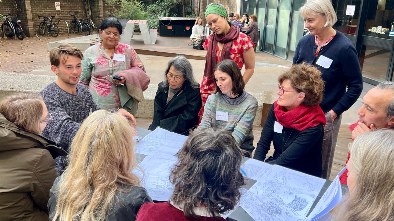 A small group of symposium attendees participate in a workshop at a table.