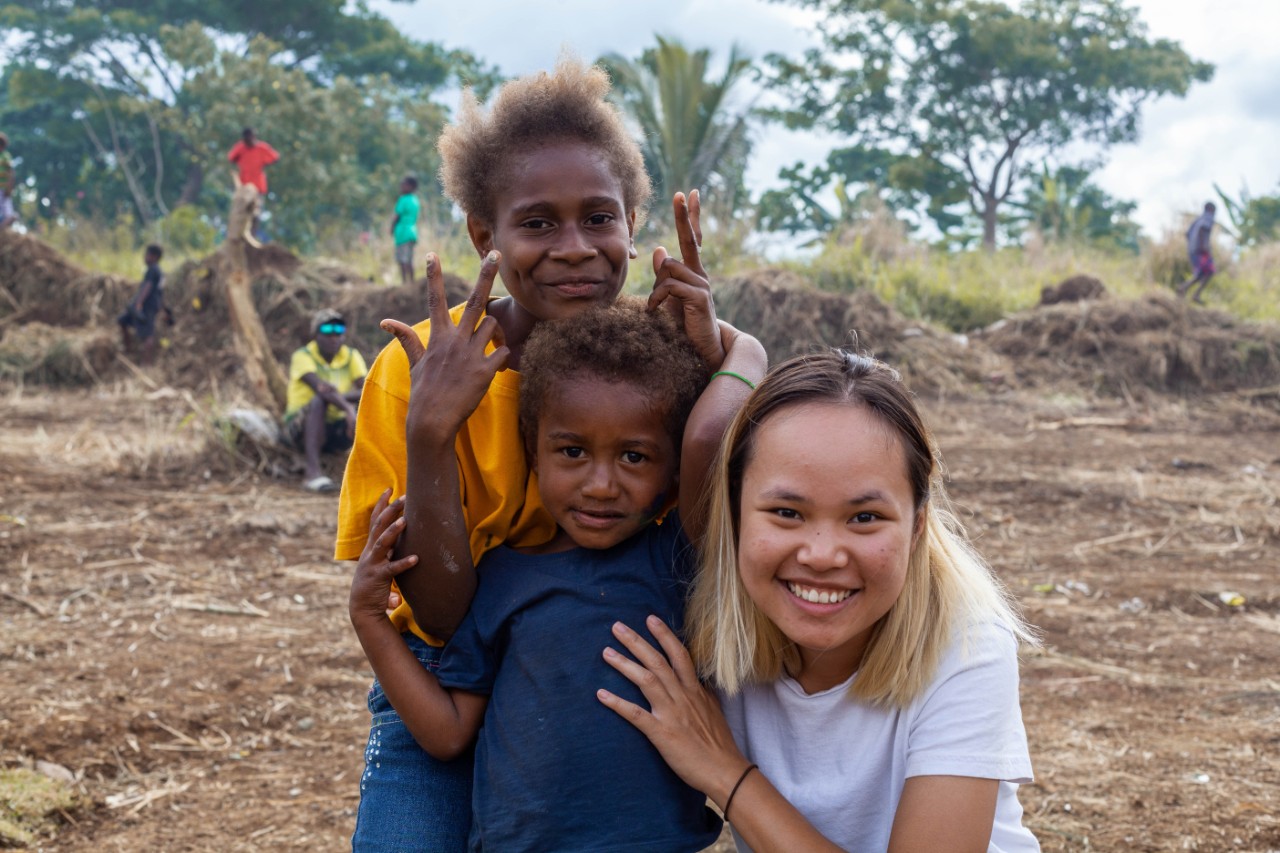Photo of architecture student Juthamas Marsh with children from the Freswind community