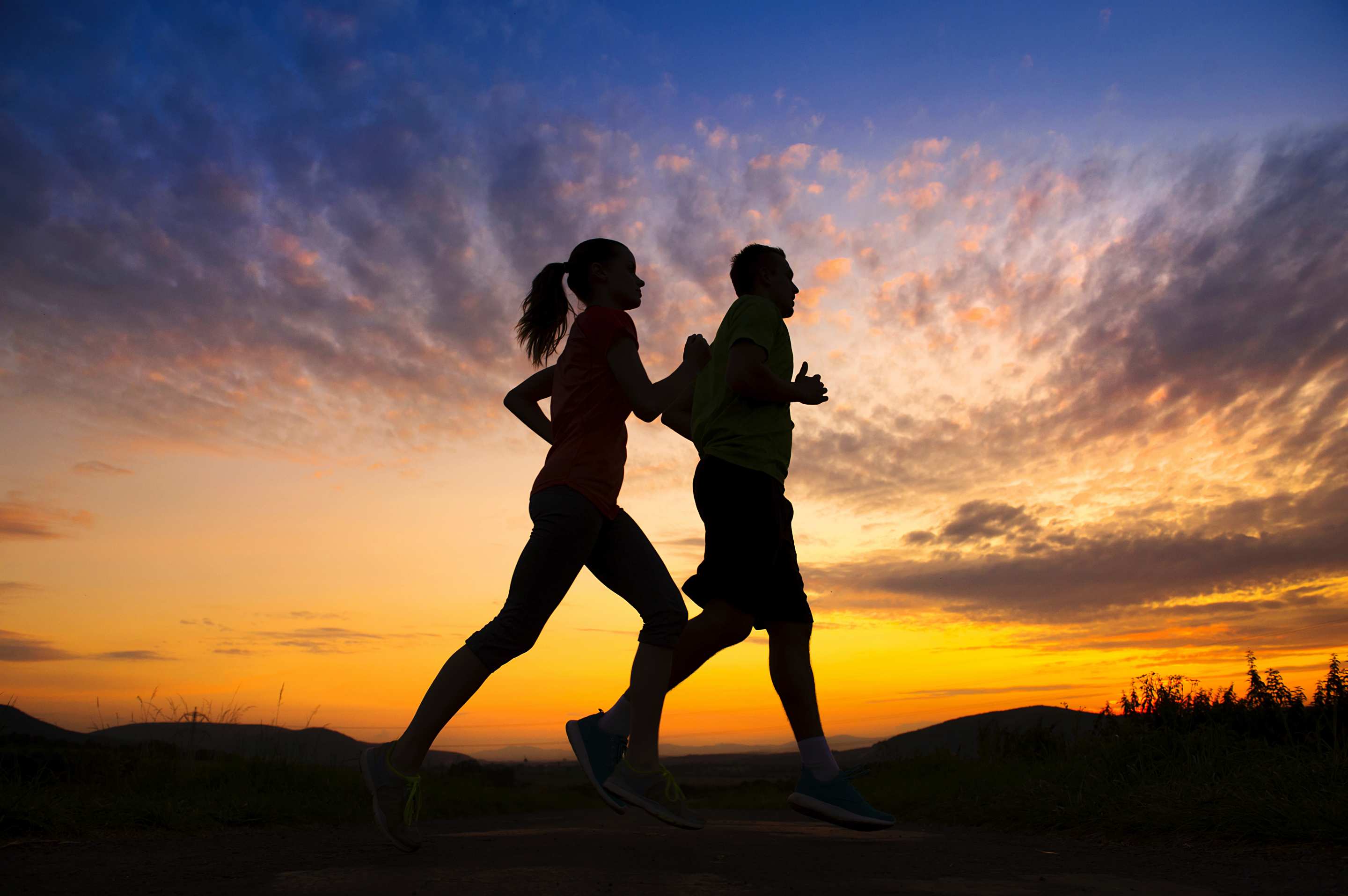 silhouette of couple running