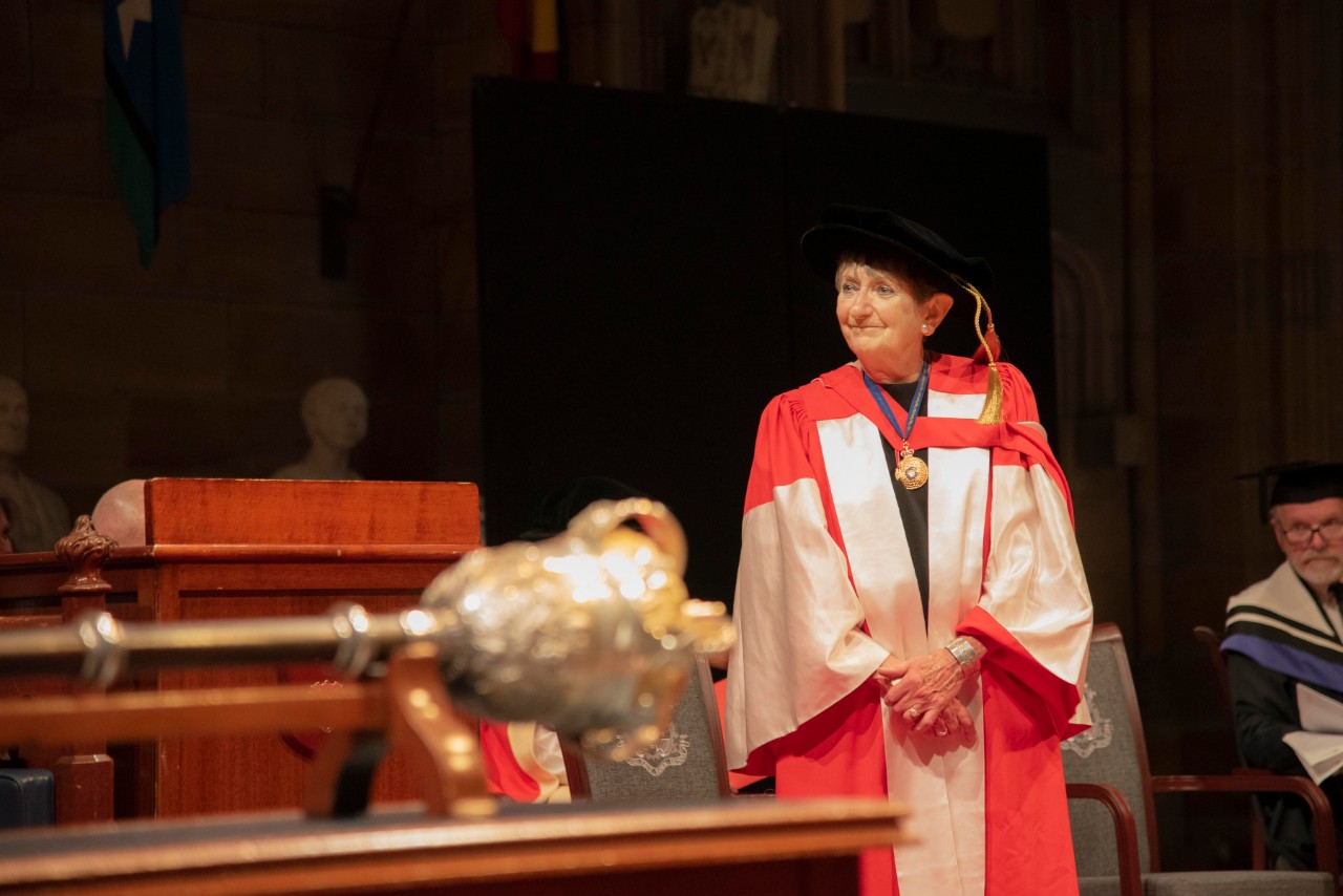 photo of Dorothy Hoddinott in graduation gown looking at someone speaking
