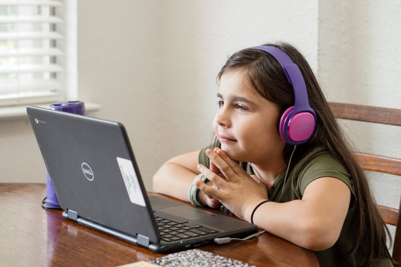 photo of a young girl doing school work at home on her laptop
