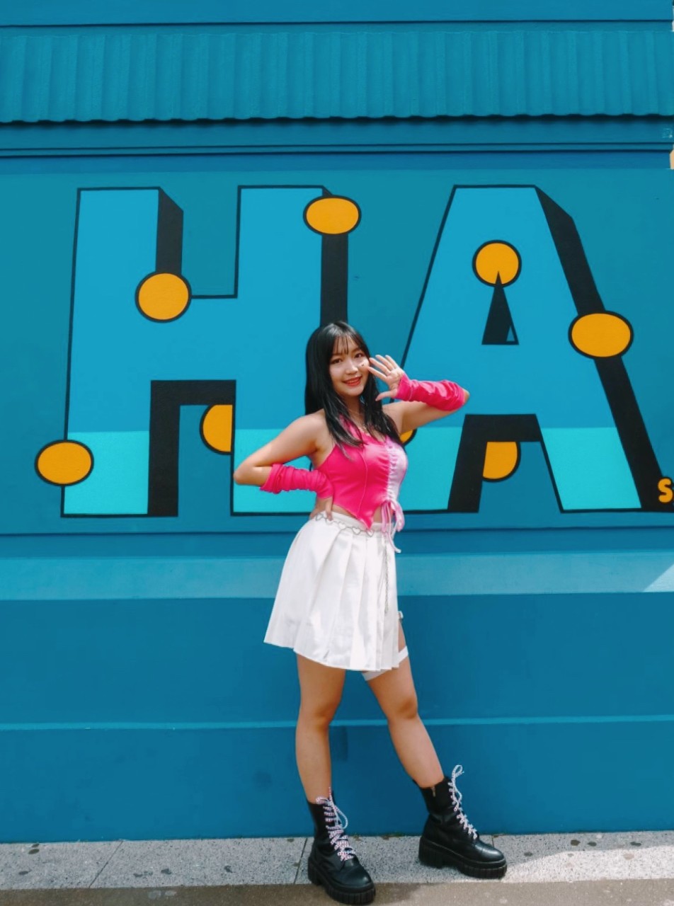 Sephira standing in front of a blue mural 