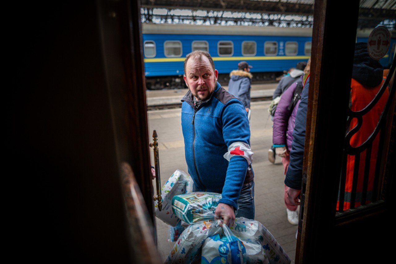 a man wearing a paramedic uniform loads medicines onto a train 